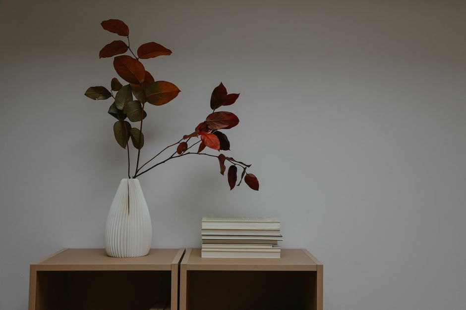 Gezellige herfsthoek met minimalistische boekenplanken.